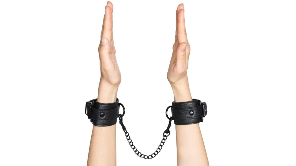 Hands with handcuffs around wrist 