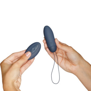 Egg vibrator with remote held in a pair of hands