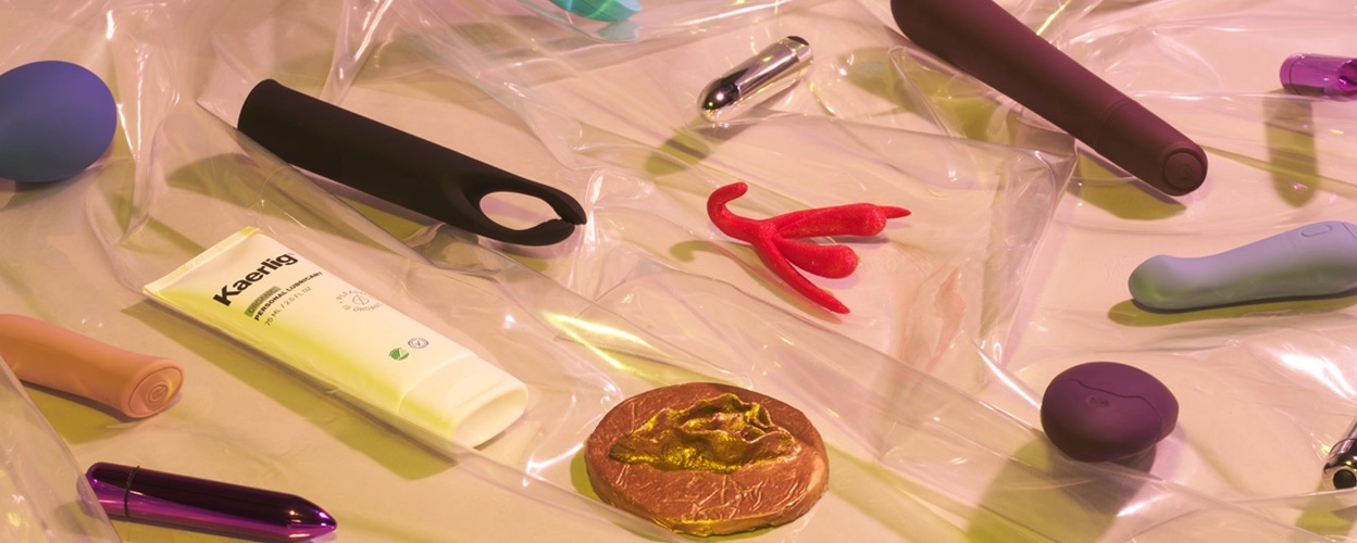 Différents sextoys, lubrifiants et figurines posés sur une table
