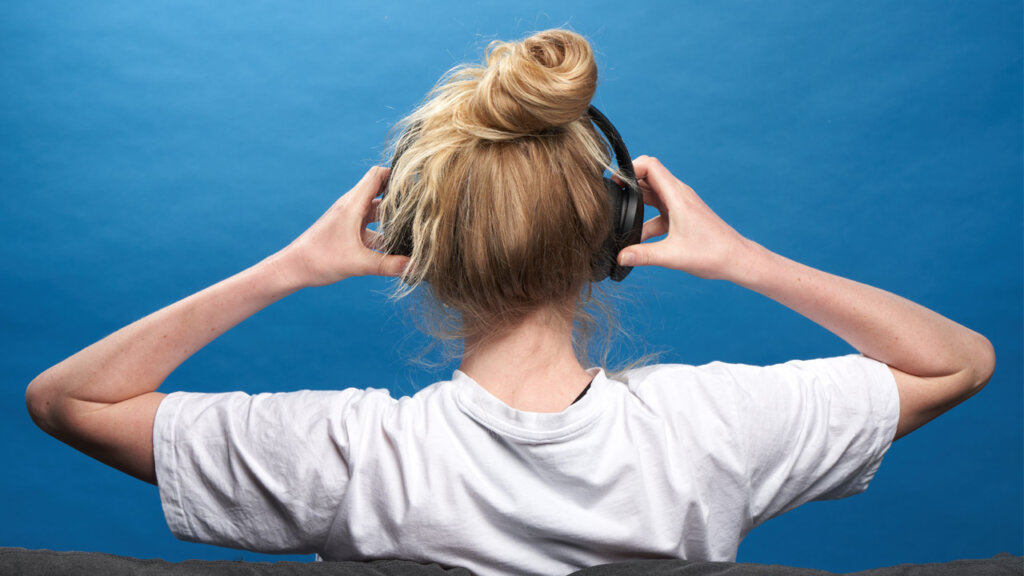 Person seen from behind with black headphones on