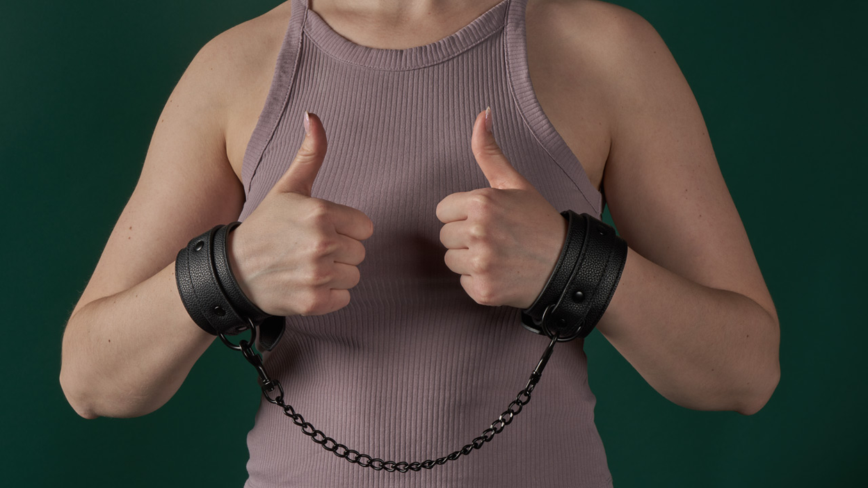 Person with a set of cuffs on the wrists doing thumbs up