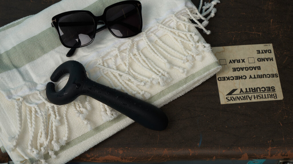 Lunettes de soleil et vibromasseur sur une couverture