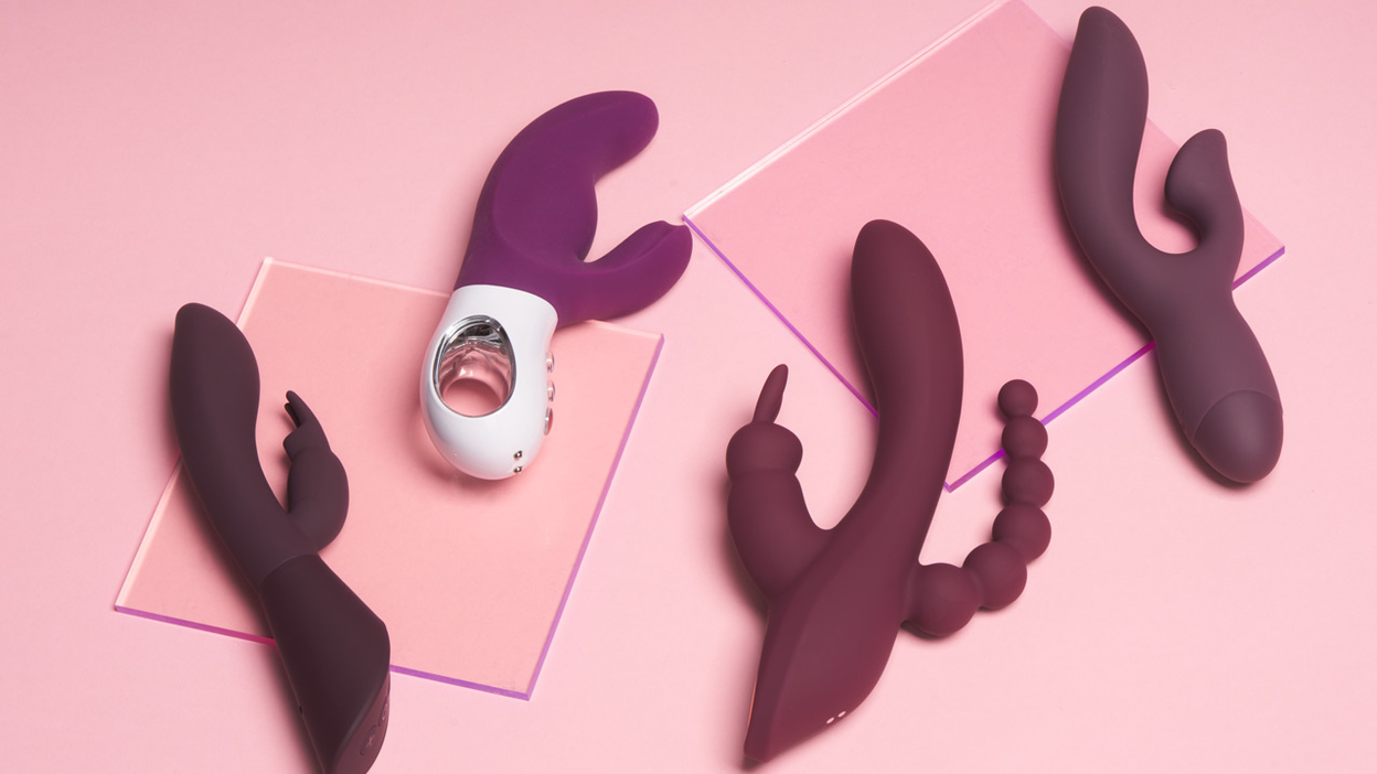 Four purple rabbit vibrators lying next to each other on a pink background