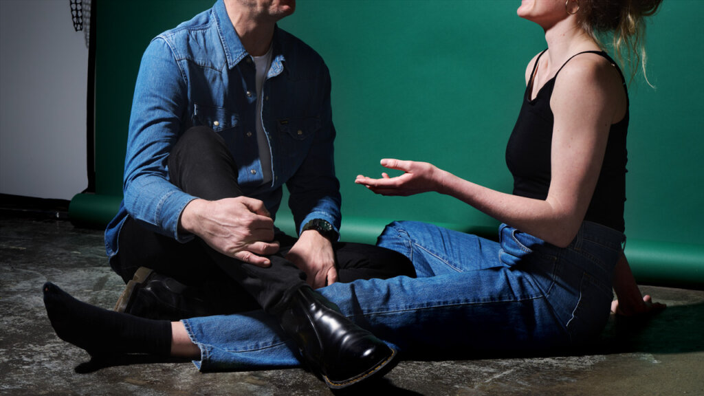 A man and a woman sitting on the floor