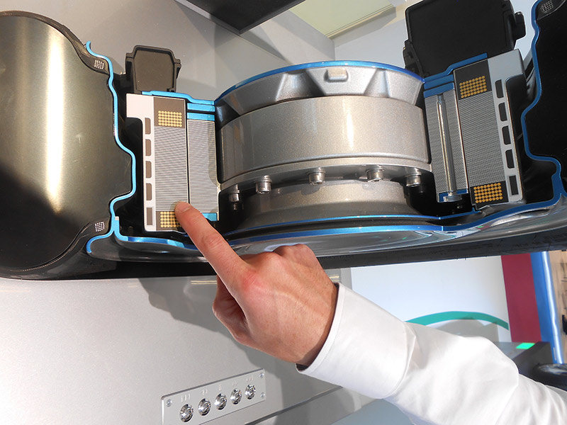 Engineer points to stator component of motor contained within electricvehicle wheel Engineer points to stator component of motor contained within electricvehicle wheel