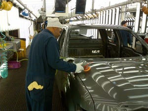 Plant worker inspects paint on F150 pickup