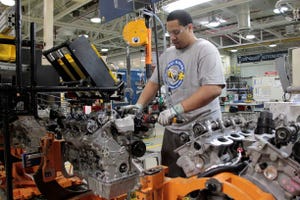 An employee installs the phasor and oil control valve on a Pentastar V-6 engine at the FCA US Mack Avenue Engine Plant in Detroit.