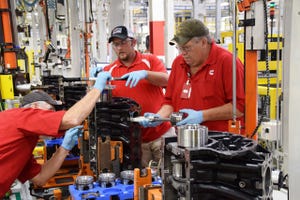Cummins employee inserts piston in Nissan 50L diesel as part of pilot production
