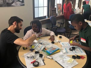 Detroit fourth-graders work with Hyundai Mobis engineer to build solar cars from kits.