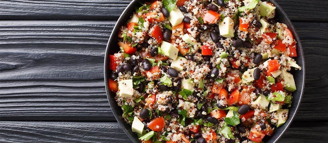 A bowl with black bean and quinoa salad with fresh vegetables Κινόα με Μαύρα Φασόλια, Λαχανικά & Χούμους