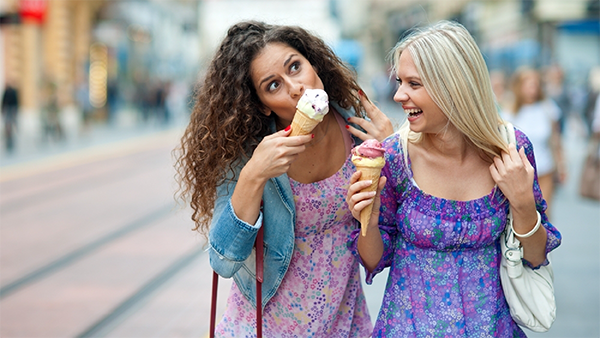Δύο κορίτσια περπατάνε και τρώνε παγωτό