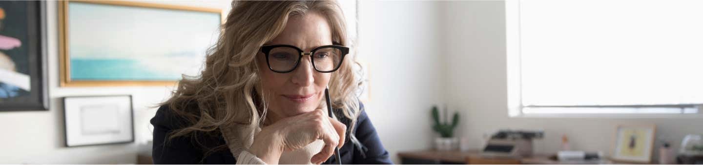 Μια γυναίκα με γυαλιά και στυλό