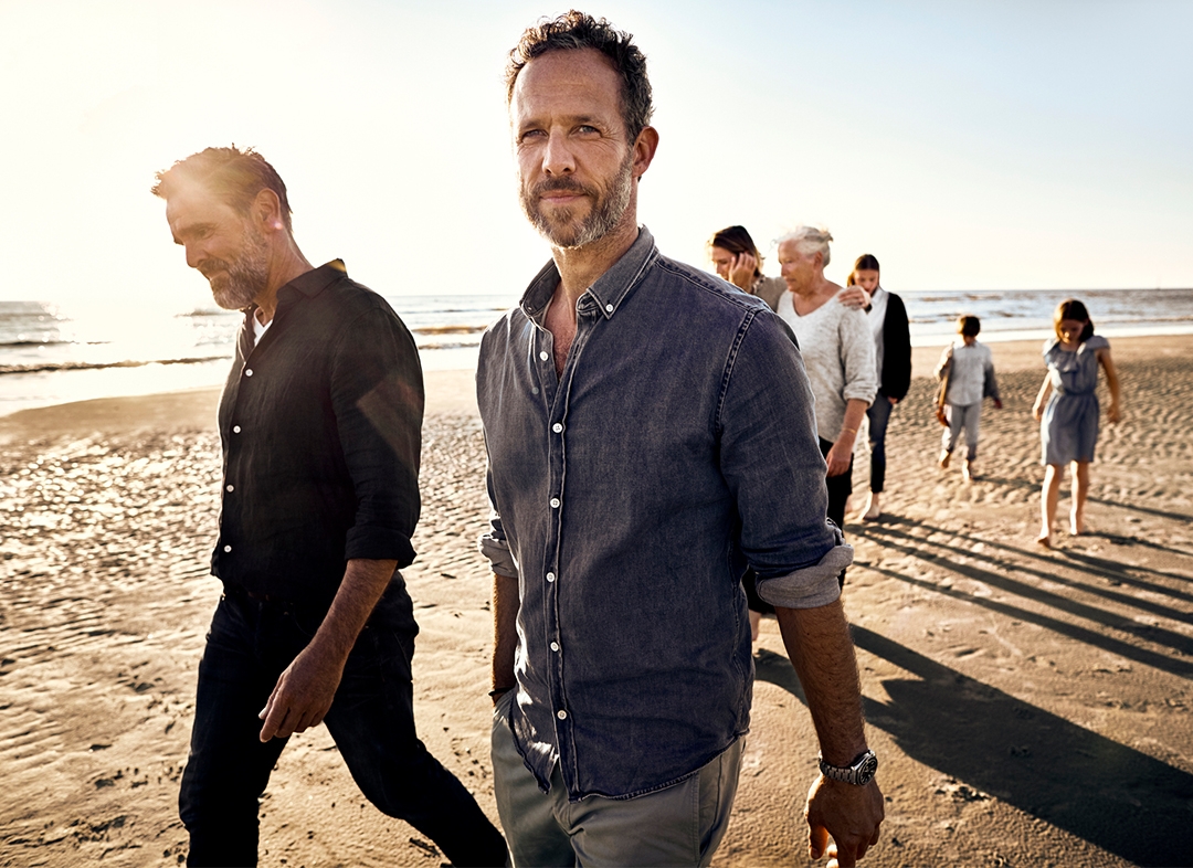 Μια οικογένεια περπατάει στην παραλία