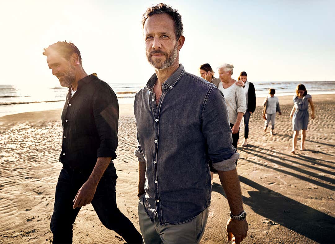 Μια οικογένεια περπατάει στην παραλία