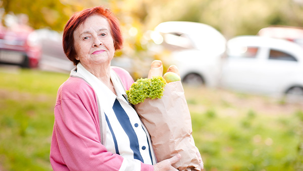 Κυρία κρατάει τα ψώνια της σε χάρτινη σακούλα