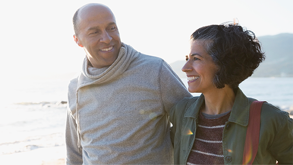 Δύο άνθρωποι περπατάνε αγκαλιασμένοι στην παραλία