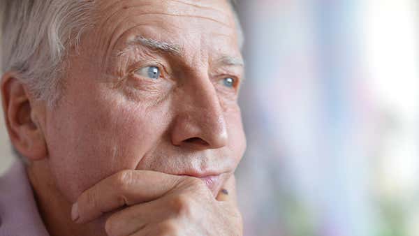 Κύριος με μπλε μάτια κρατάει το πρόσωπό του