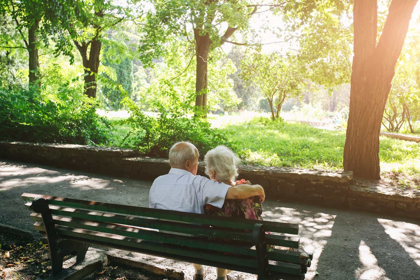 Ένα ζευγάρι ηλικιωμένων κάθεται αγκαλιασμένο σε ένα παγκάκι