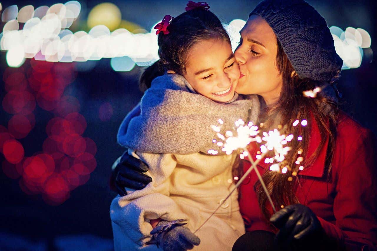 Μια γυναίκα φιλάει στο μάγουλο την κόρη της