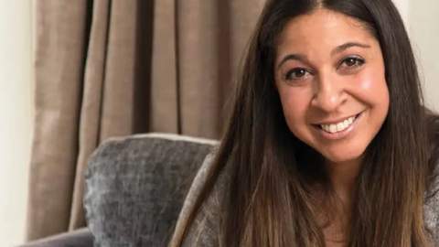 Μια γυναίκα  χαμογελάει στην κάμερα