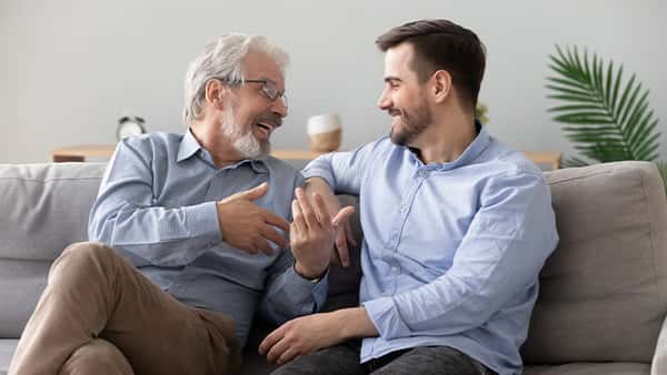 Δύο άντρες κάθονται στον καναπέ κι έχουν μία ευχάριστη συζήτηση