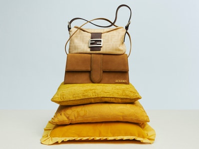 Two designer bags, balanced on yellow cushions.