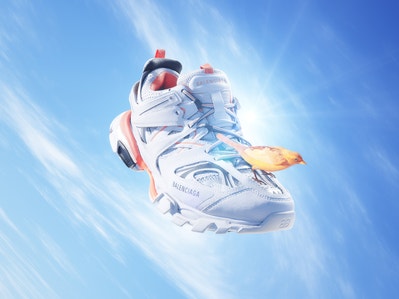 Abstract image of a floating trainer shoe. A bird is perched on the laces of the shoe.