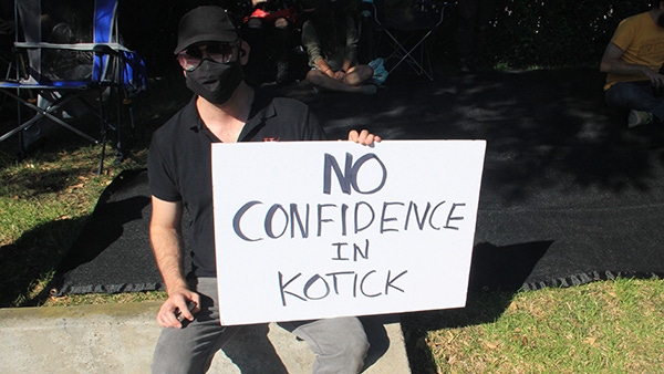 An Activision Blizzard employee holds a sign saying "no confidence in Kotick."