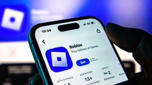 A photo of a phone displaying the Roblox page on the iOS App Store. A photo of a phone displaying the Roblox page on the iOS App Store.