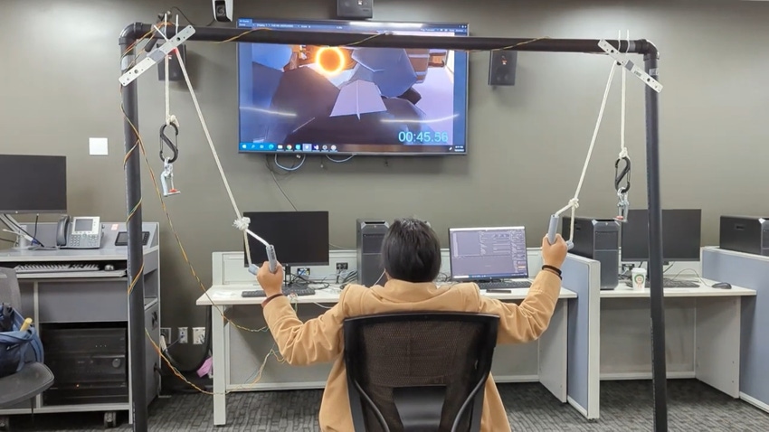 a person sits with a pulley system in each hand, using it to guide a plane's flight on the screen in front of them