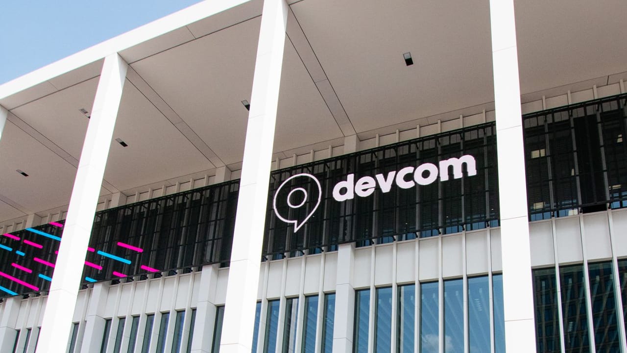 The Devcom logo on the side of a building The Devcom logo on the side of a building