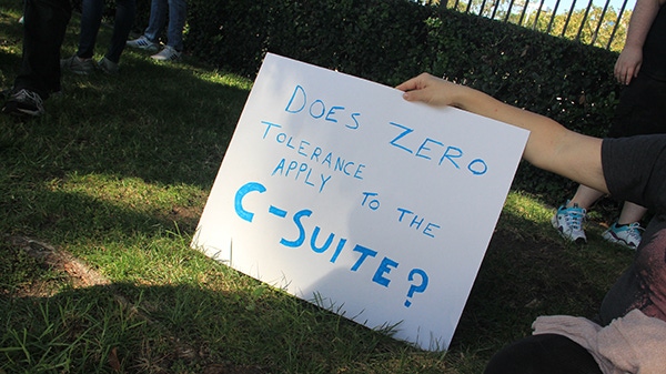 An Activision Blizzard employee holds a sign asking "does zero tolerance apply to the C-Suite?"