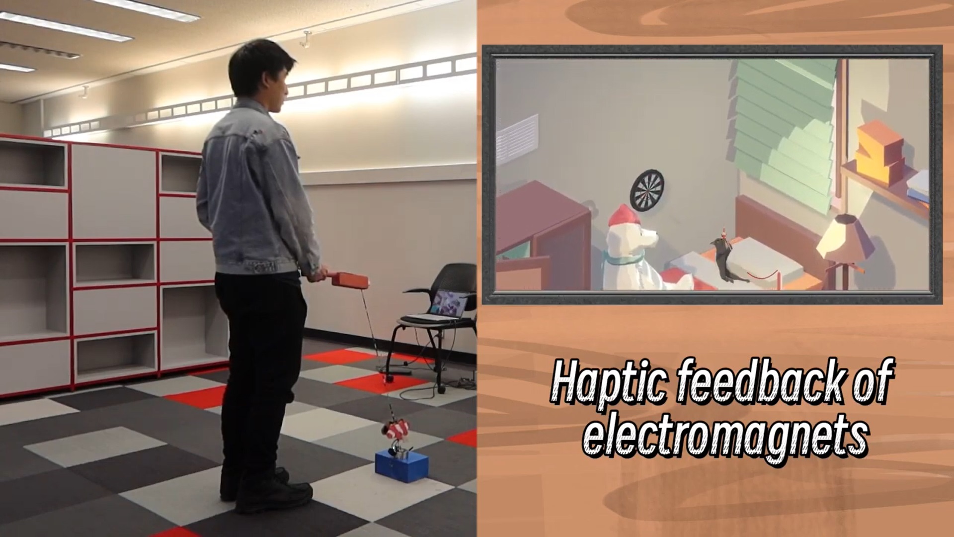a person pulls on a stick controller that is attached to an electromagnet while a cat plays on a screen