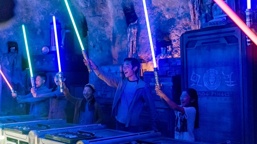 a family of guests raising their lightsabers at Star Wars: Galaxy's Edge