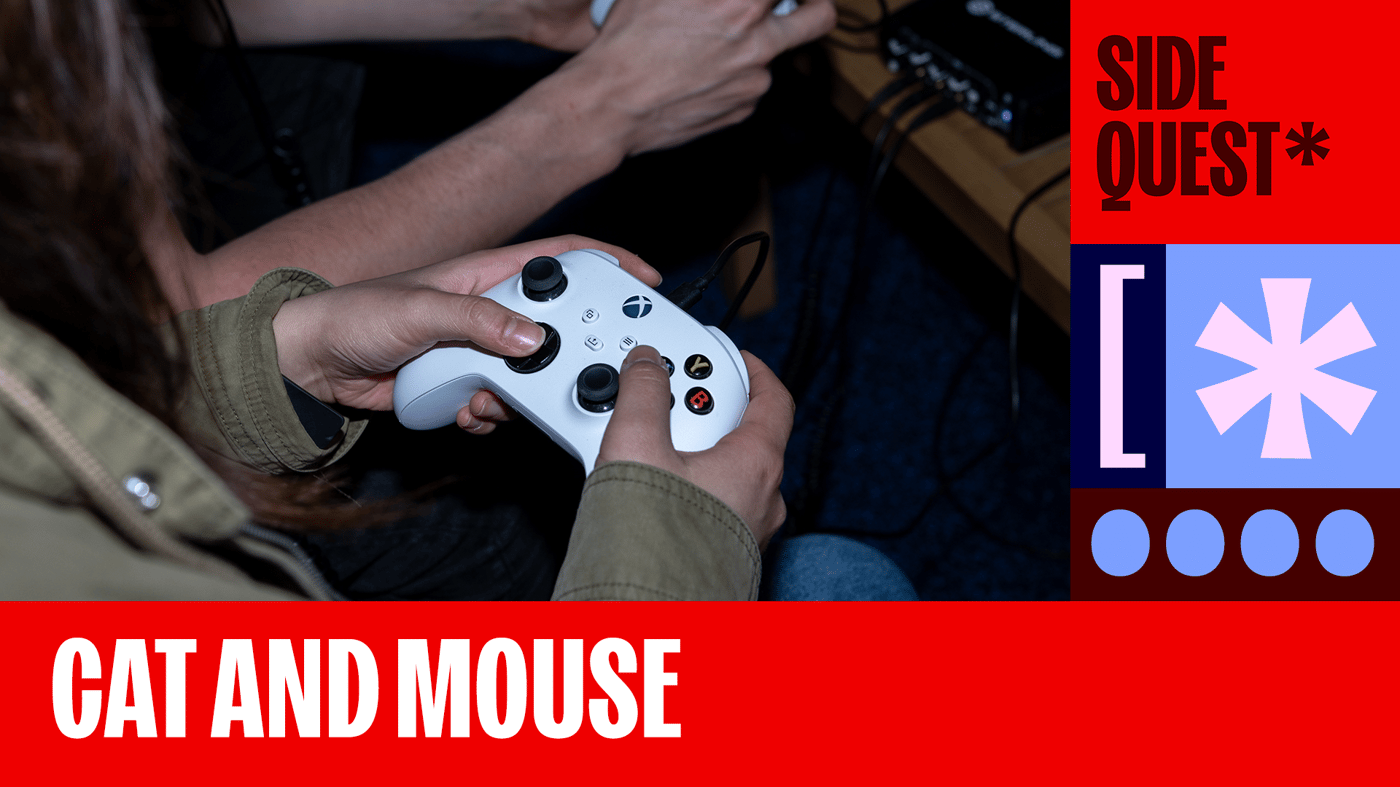 A person holds a controller next to the words "Cat and Mouse." A person holds a controller next to the words "Cat and Mouse."