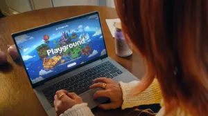 A woman looks at a laptop that says Google Playground. A woman looks at a laptop that says Google Playground.