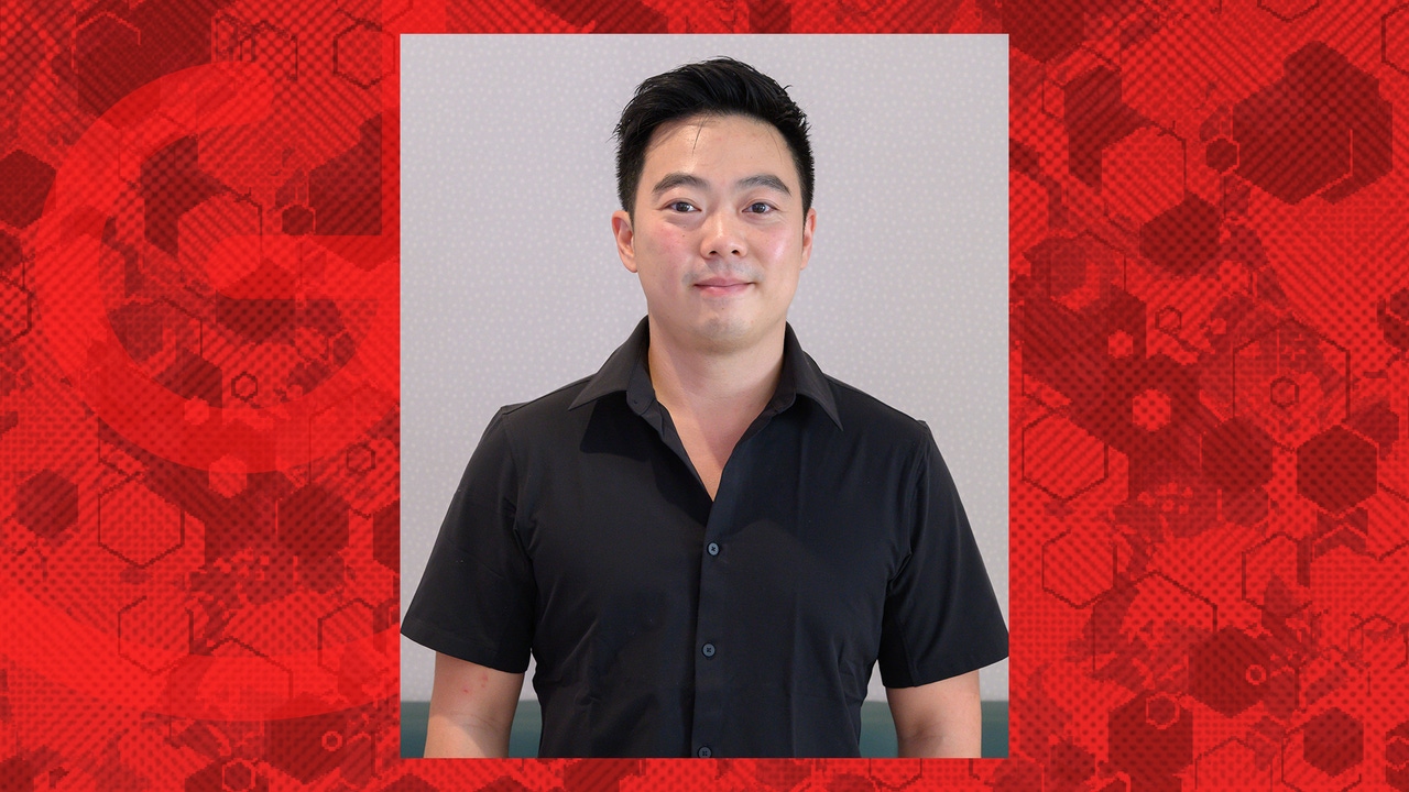A headshot of Dominic Law against a red background. A headshot of Dominic Law against a red background.