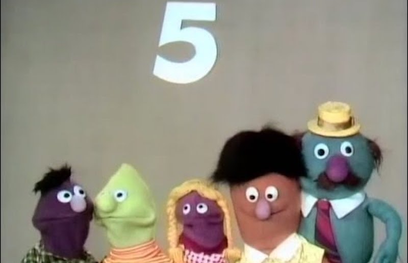 5 Sesame Street puppets stand beneath the number 5