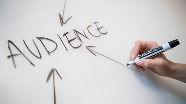 The word "Audience" written on a whiteboard with arrows pointed toward it The word "Audience" written on a whiteboard with arrows pointed toward it