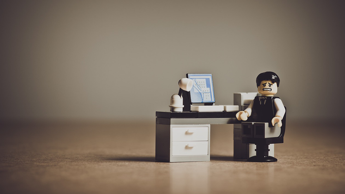 A lego minifigure receives bad news in their lego office