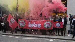 A group of union protestors holding smoke canisters outside the office of a video game company A group of union protestors holding smoke canisters outside the office of a video game company