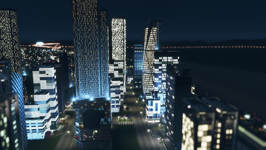 A screenshot from Cities: Skylines showing a panoramic vista of a skyscraper cluster at night
