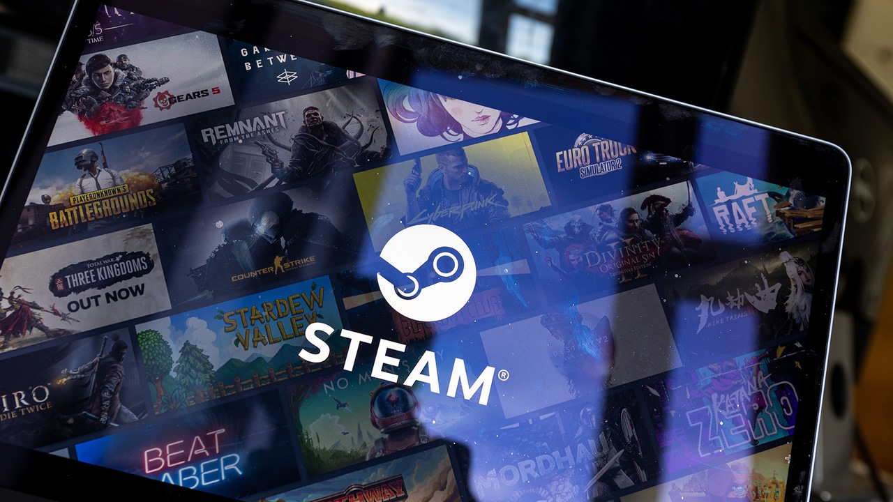 The Steam logo on a laptop with multiple game screenshots behind it The Steam logo on a laptop with multiple game screenshots behind it