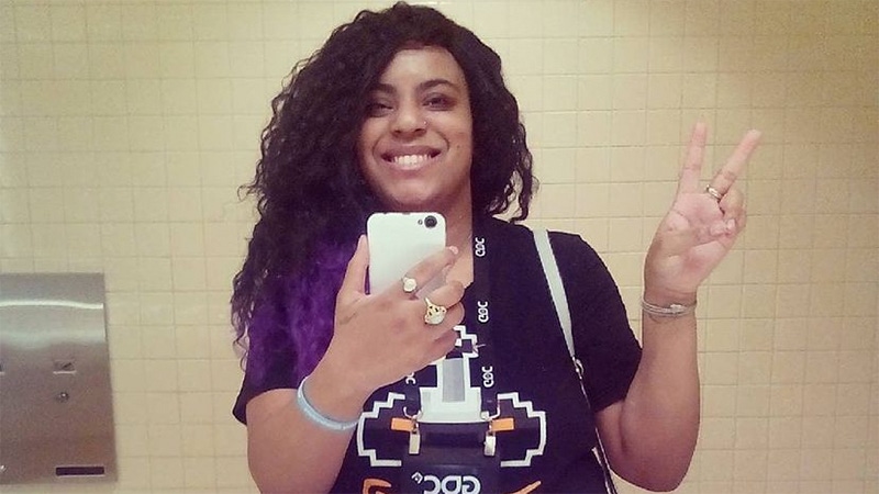 A photograph of Undrea Leach. She is throwing a "peace" sign while taking a mirror selfie at GDC. A photograph of Undrea Leach. She is throwing a "peace" sign while taking a mirror selfie at GDC.