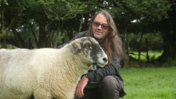 Jeff Minter pets a sheep.