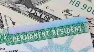 A photograph of a US Passport, social security card, and green card against an American flag. A photograph of a US Passport, social security card, and green card against an American flag.