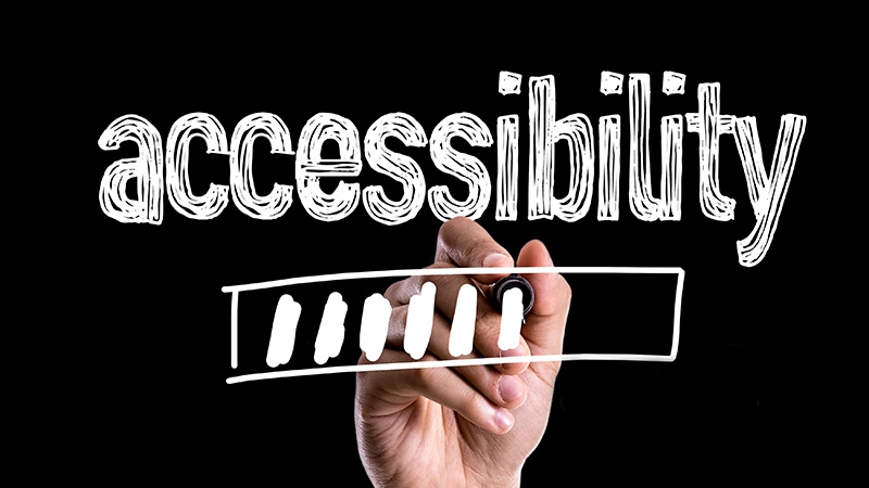 A hand writes the words "accessibility" in whiteboard marker.