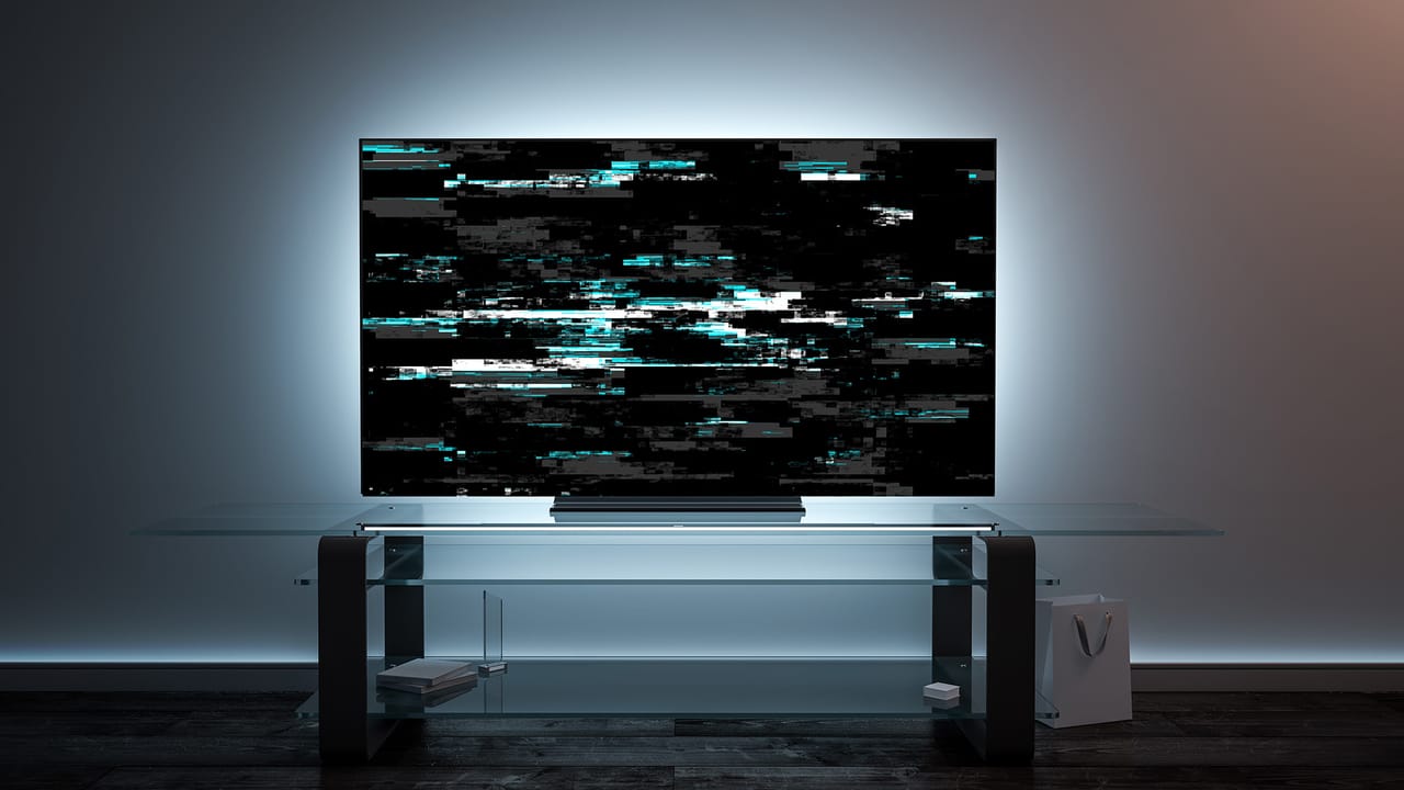 A TV on a glass stand displaying a corrupted, pixelated image. A TV on a glass stand displaying a corrupted, pixelated image.
