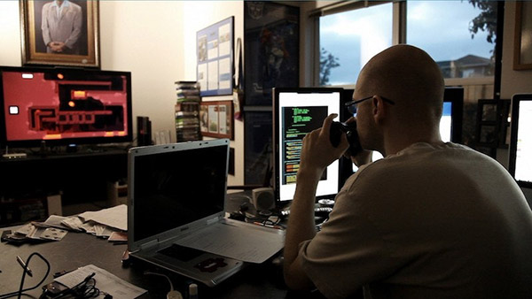 A man looks at his computer in a screencap from Indie Game: The Movie