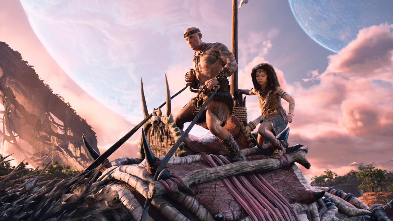 A character played by Vin Diesel and a small child ride a dinosaur in Ark 2. A character played by Vin Diesel and a small child ride a dinosaur in Ark 2.